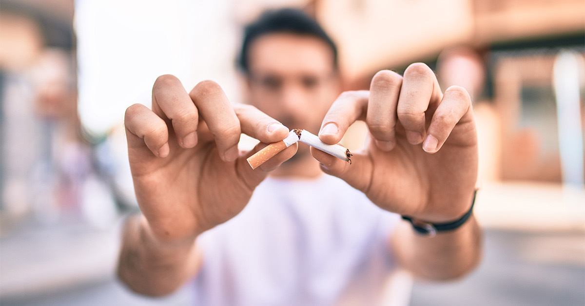 Man snapping a cigarette in half.